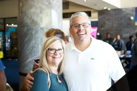 Man and woman with glasses smiling for photo at church conference
